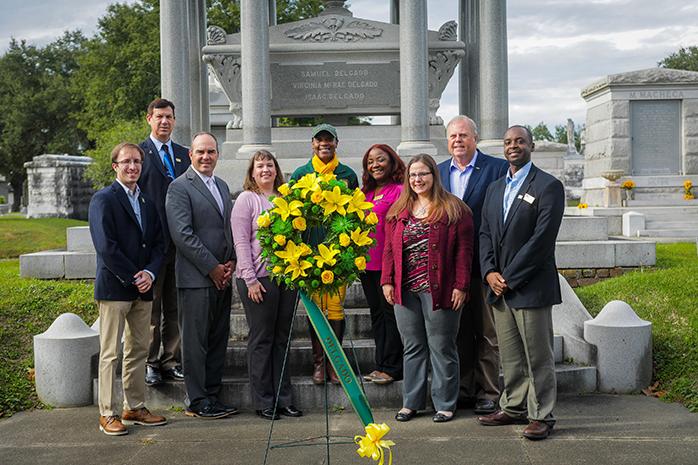 Delgado faculty and staff pose in front of Isaac Delgado's grave in celebration of Founder's Day.