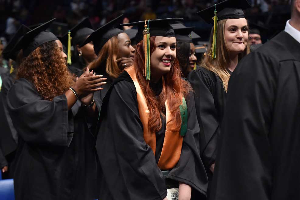 A Delgado graduate smiles during the Spring 2018 commencement ceremony