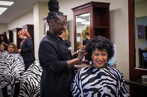 student fixing hair in the cosmetology class