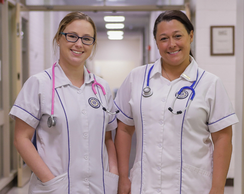 two female nursing students standing in a hall way