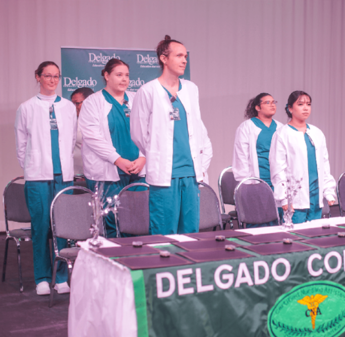 Nursing Students at Convocation Nursing Students standing at Convocation ceremony in front of awards table.