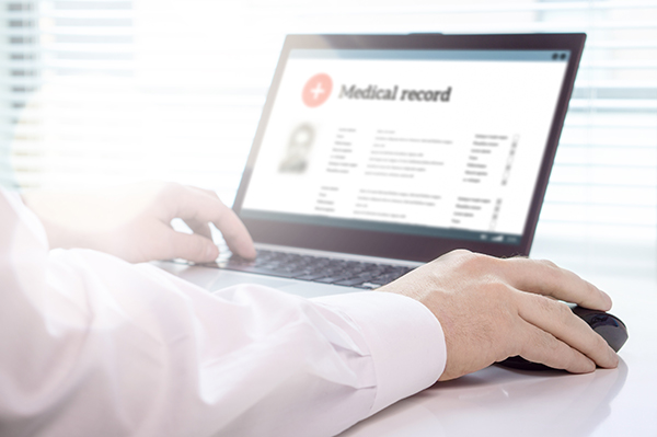 close up of hand using a computer to look up health records