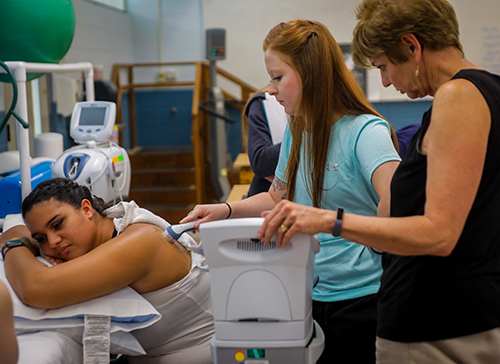 Student giving treatment to a patient's shoulder