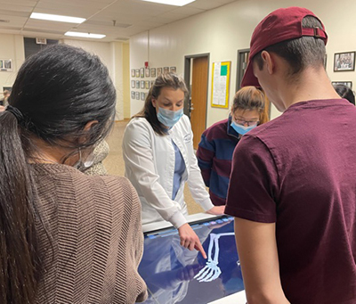 Instructor showing students and x-ray of skeleton hand and wrist