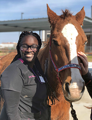 vet tech student standing next to a horse