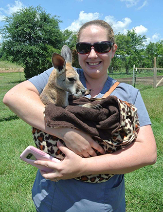 student holding a baby kangaroo