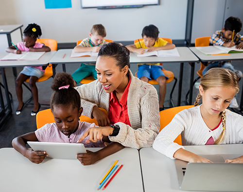 Teacher helping student sitting at their desk