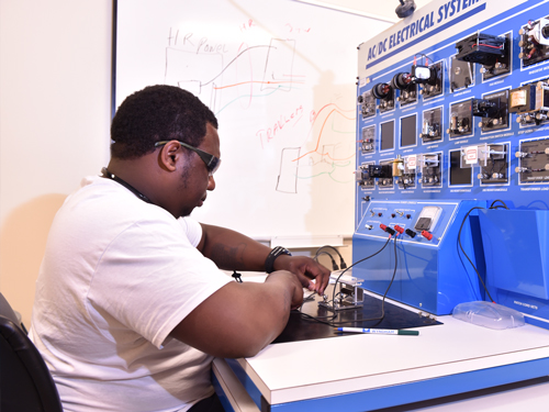 Student practicing on a electrical system simulator