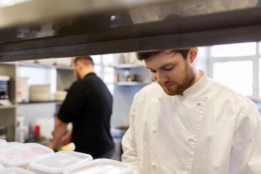 A cook works in a restaurant kitchen.