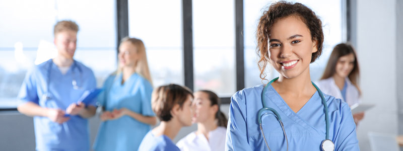 female nursing students standing with classmates in the background