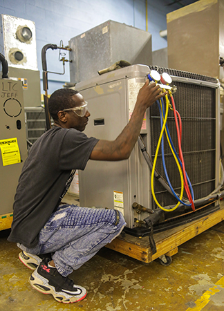 student working on a large ac unit