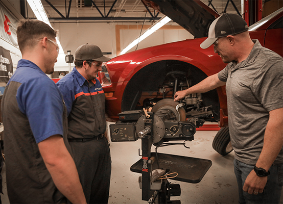 instructor showing students automotive brake