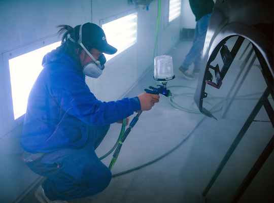 student spray painting a fender