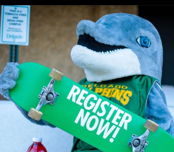 delgado dolphin mascot holding a skateboard