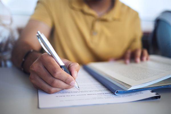 close up of a student (his hand writing) taking an exam