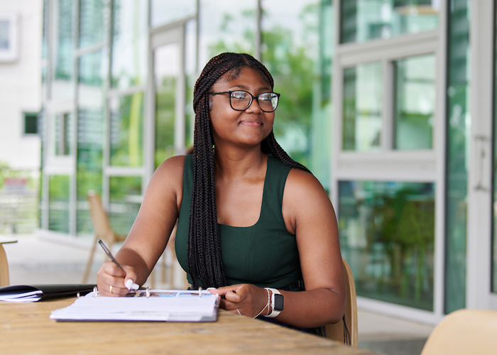 female student studying outside a building