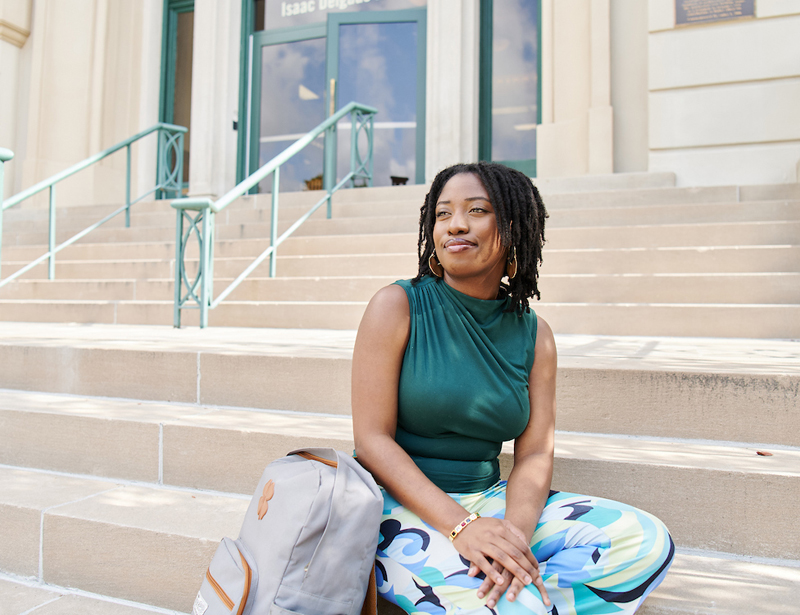 black female student on steps of building 1