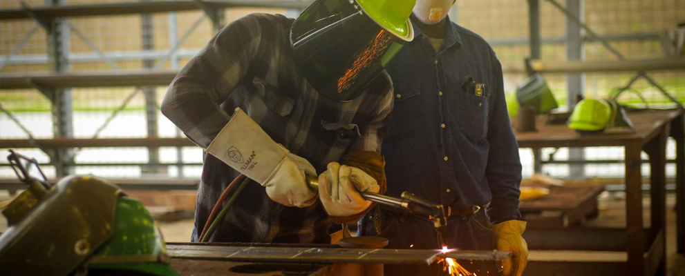 A male advanced manufacturing student working machine