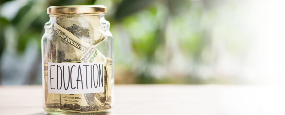 glass jar with cash in it and education lable on the jar