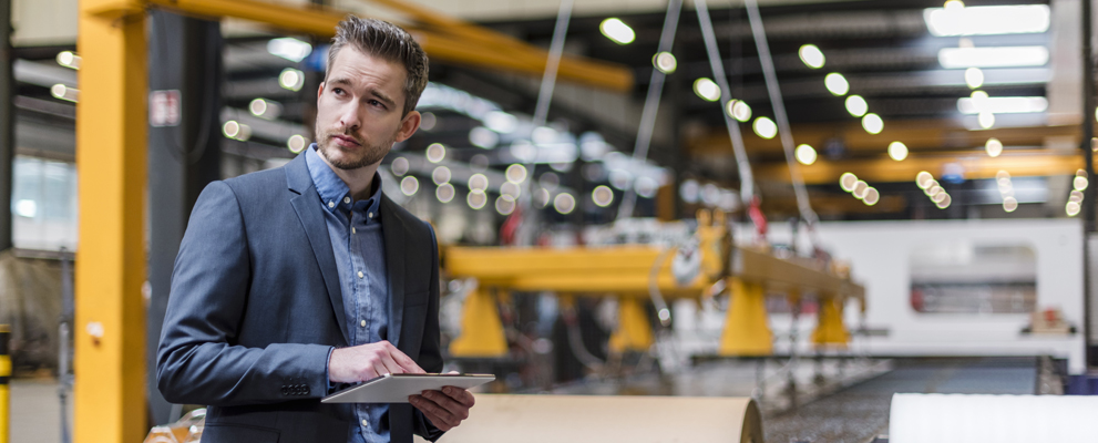 Businessman using tablet on factory floor