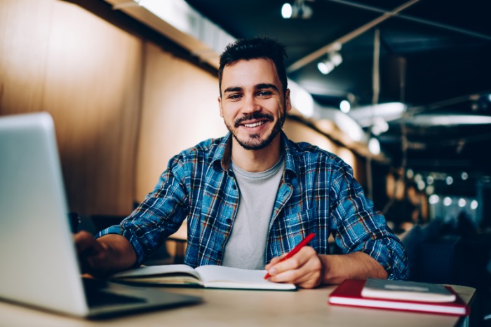 male student smiling at a computer