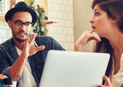 african american male and white female in front of a laptop