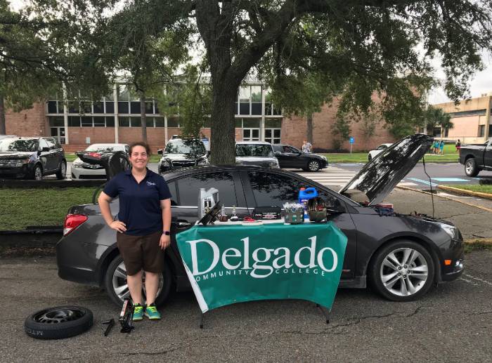 Samantha Candler, instructor of Motor Vehicle Technology, poses in front of a black sedan.