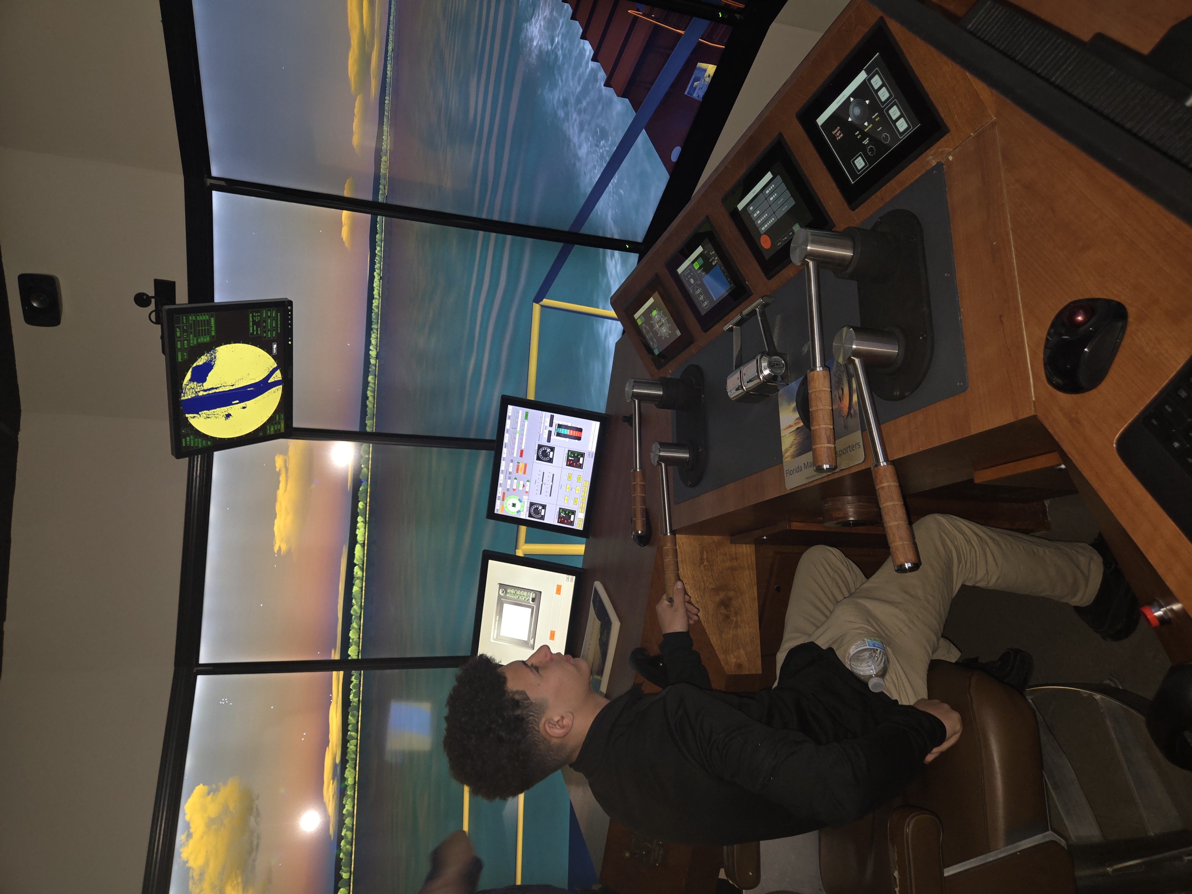A charter school student uses a maritime simulator