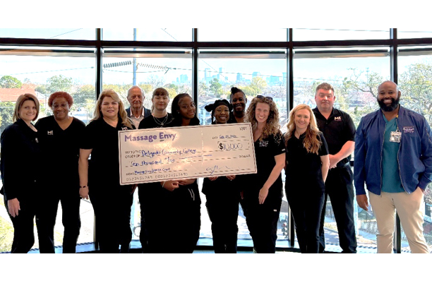 group shot of massage students with a big check