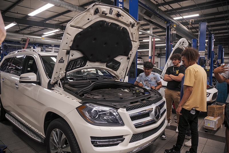 students looking at a car engine