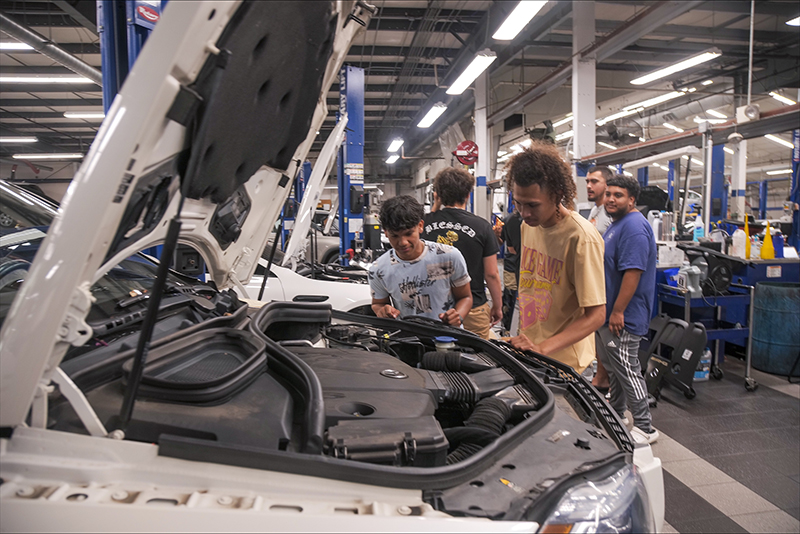 students looking at a car engine