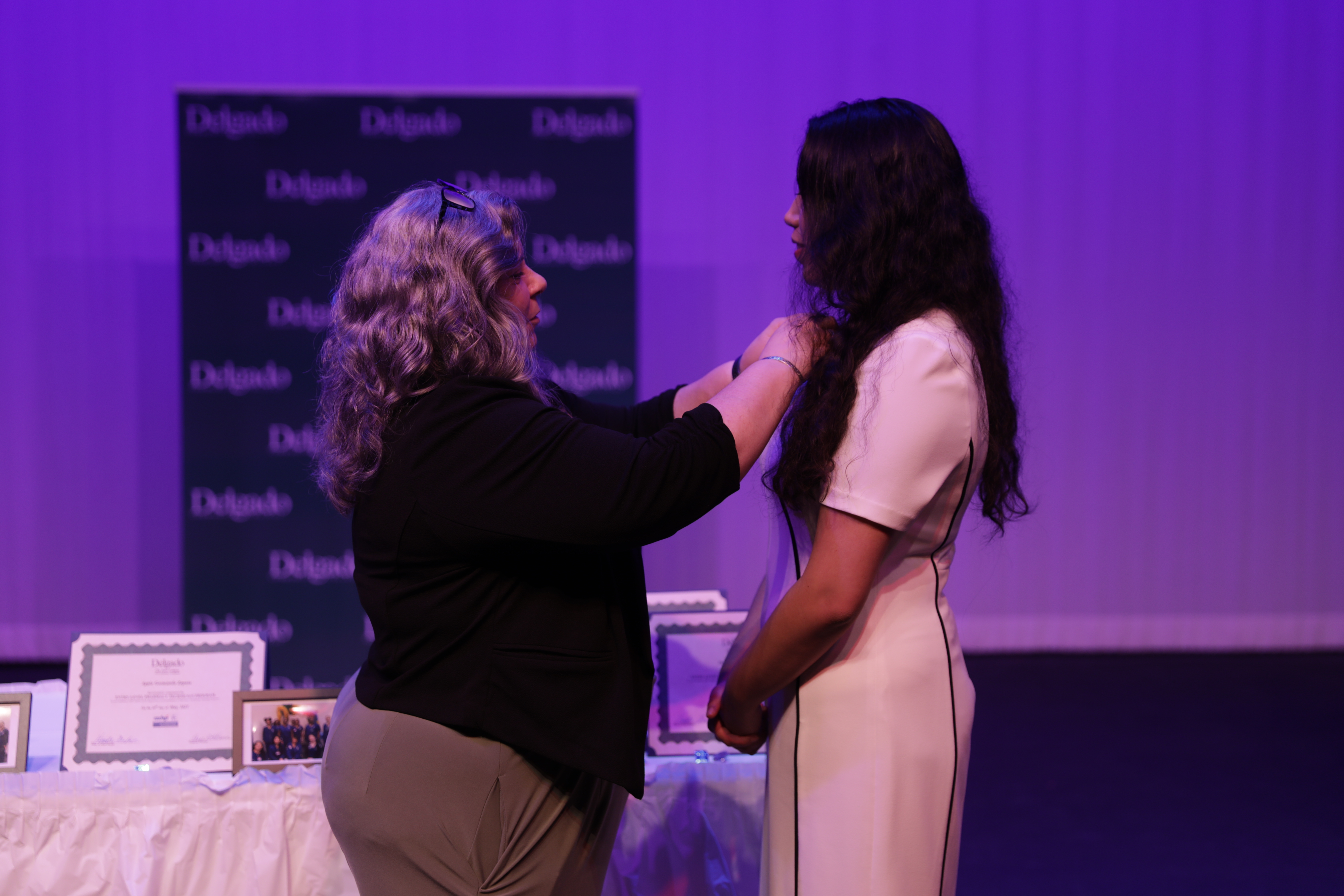 Program Director Anne LaVance pins a pharmacy tech graduate