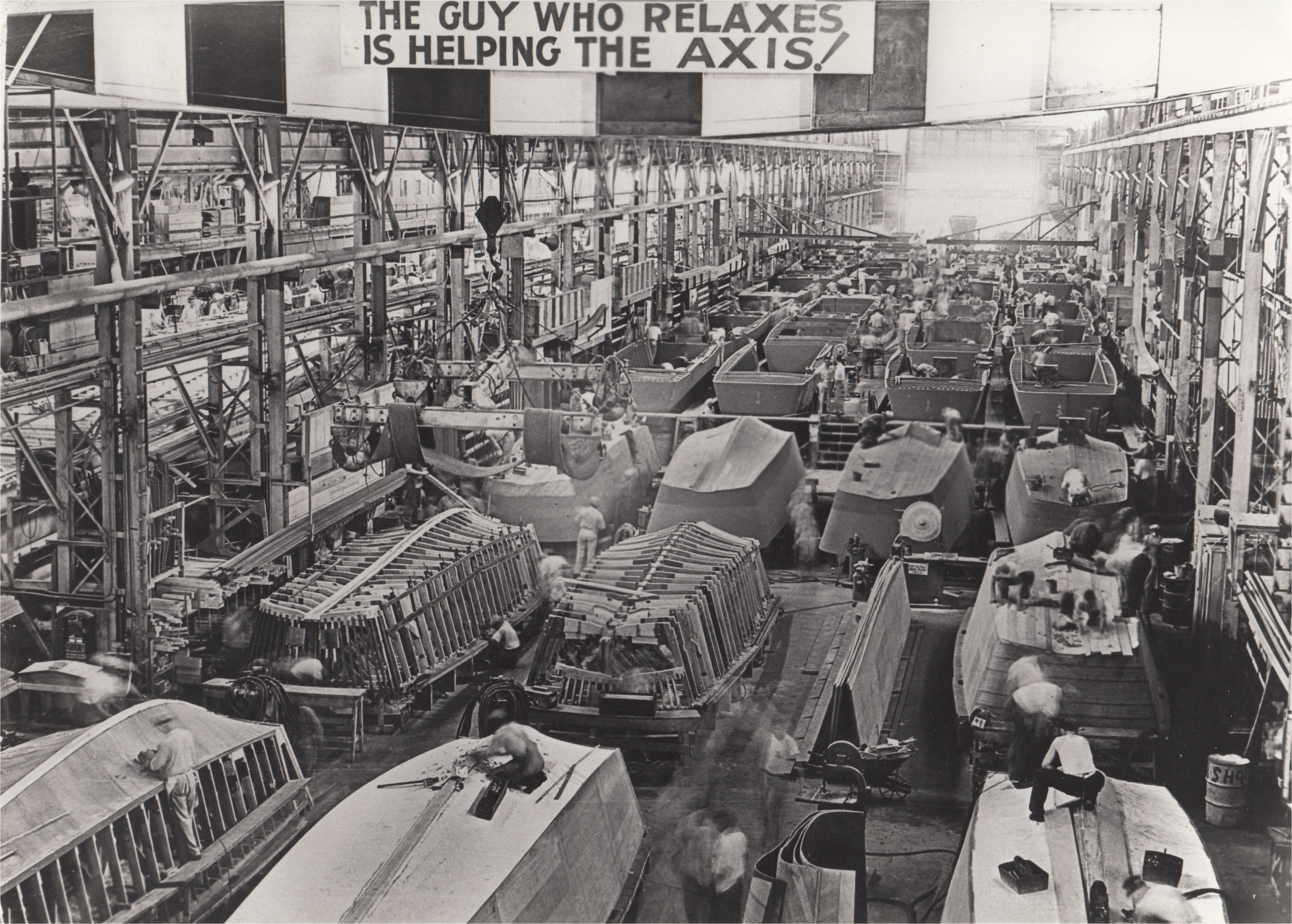 A sign in the Higgins boat factory reads "The guy who relaxes is helping the axis!"