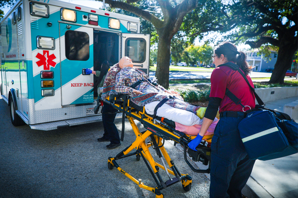 students loading a dummy into a emergency vehicle