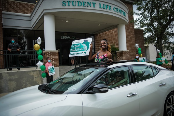 Delgado Spring 2020 graduate with sign