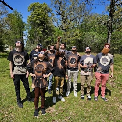 Students wearing protective glasses look up at the sky