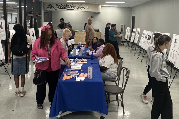 people looking at the different exhibits at the event