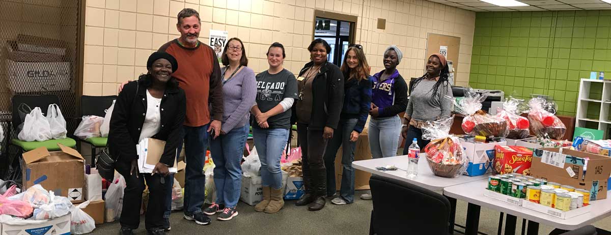 Members of the Single Stop staff pose proudly with the bounty that they have collected for their food bank.