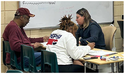 students at a desk being tutored