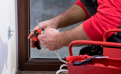 Residential Electrician working on wall outlet